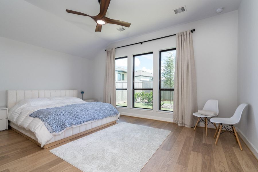 Revwood flooring continues into the primary bedroom with a remote controlled ceiling fan. Revwood flooring continues into the primary bedroom with a remote controlled ceiling fan.