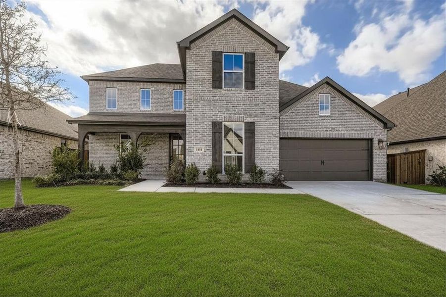 Traditional home featuring brick siding, an attached garage, driveway, a porch, and a shingled roof