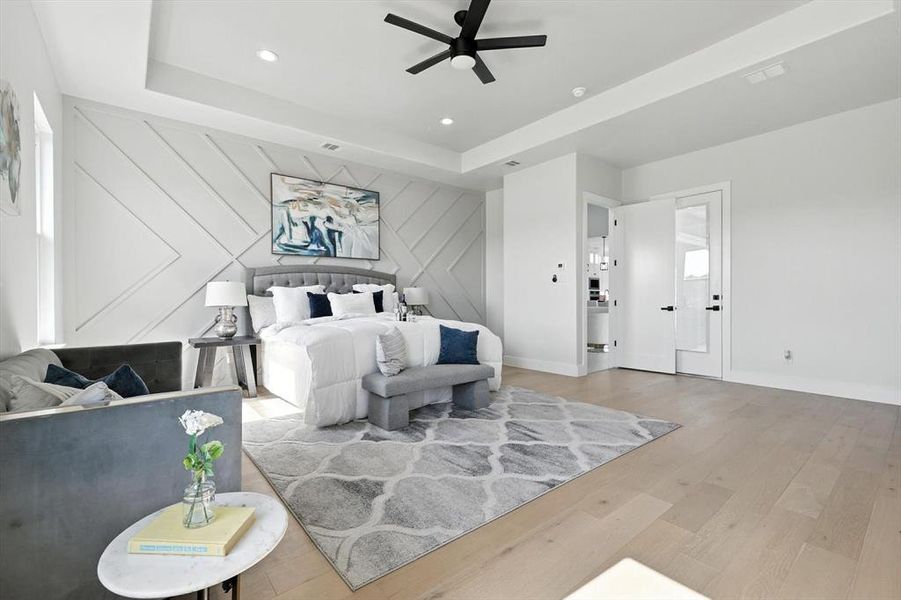 Bedroom featuring wood finished floors, a tray ceiling, recessed lighting, and a ceiling fan Bedroom featuring wood finished floors, a tray ceiling, recessed lighting, and a ceiling fan