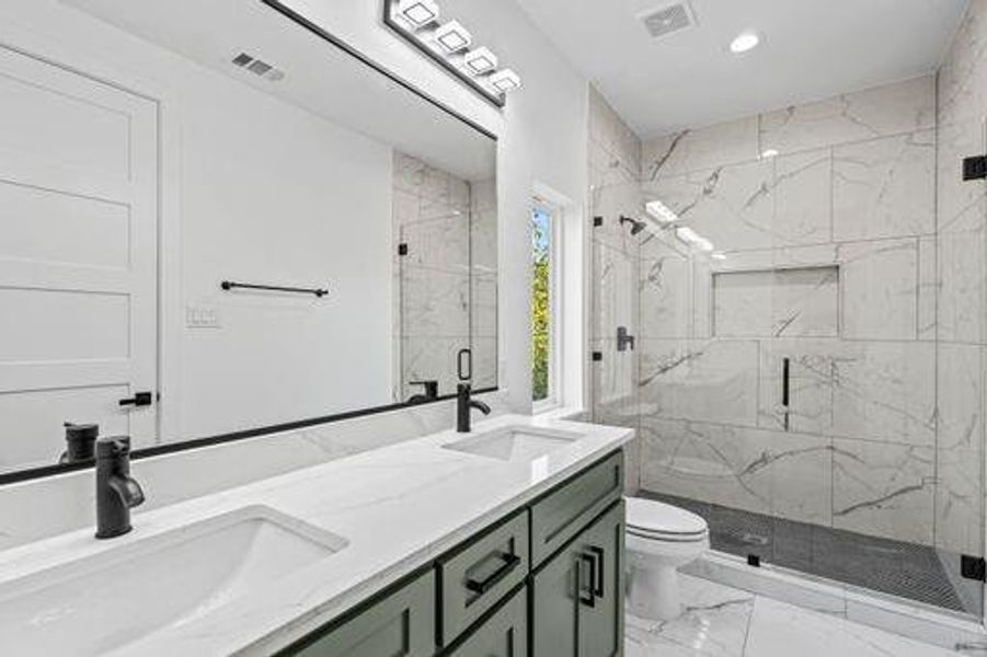 Bathroom with a shower with door, vanity, and toilet