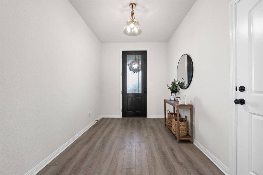 Entryway featuring baseboards and wood style floors Entryway featuring baseboards and wood style floors