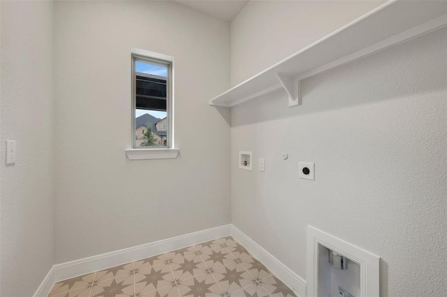 Dedicated utility space featuring patterned floor tile, a single window, white baseboards, and an integrated white shelving unit