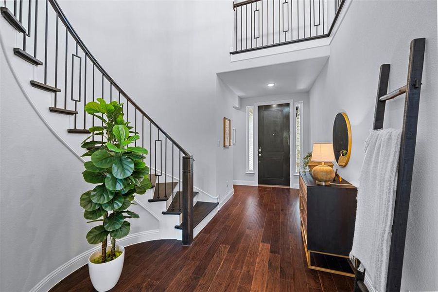 Entryway featuring wood finished floors, a towering ceiling, stairway, and recessed lighting