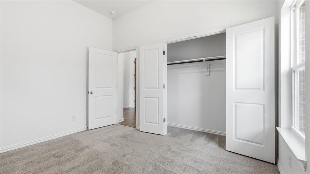 Room featuring light gray carpeting, white walls, and a window with white trim