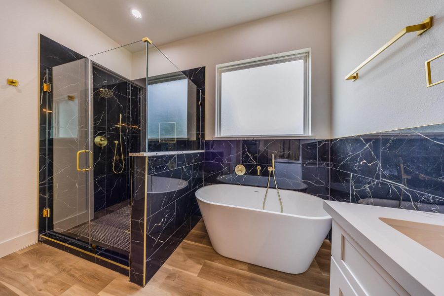 Primary bath showcases blue luxury tile with elegant gold touches, creating a sophisticated, spa-like retreat with modern charm. Primary bath showcases blue luxury tile with elegant gold touches, creating a sophisticated, spa-like retreat with modern charm.