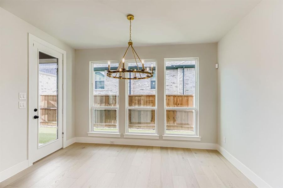 Unfurnished dining area with a chandelier and light wood-style floors