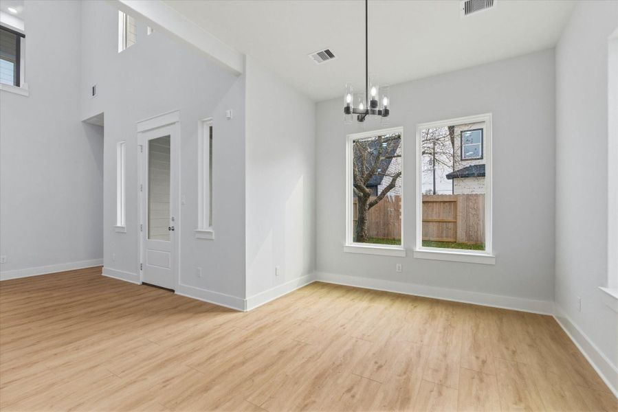 The spacious dining area is surrounded by large picture windows that fill the space with natural light.