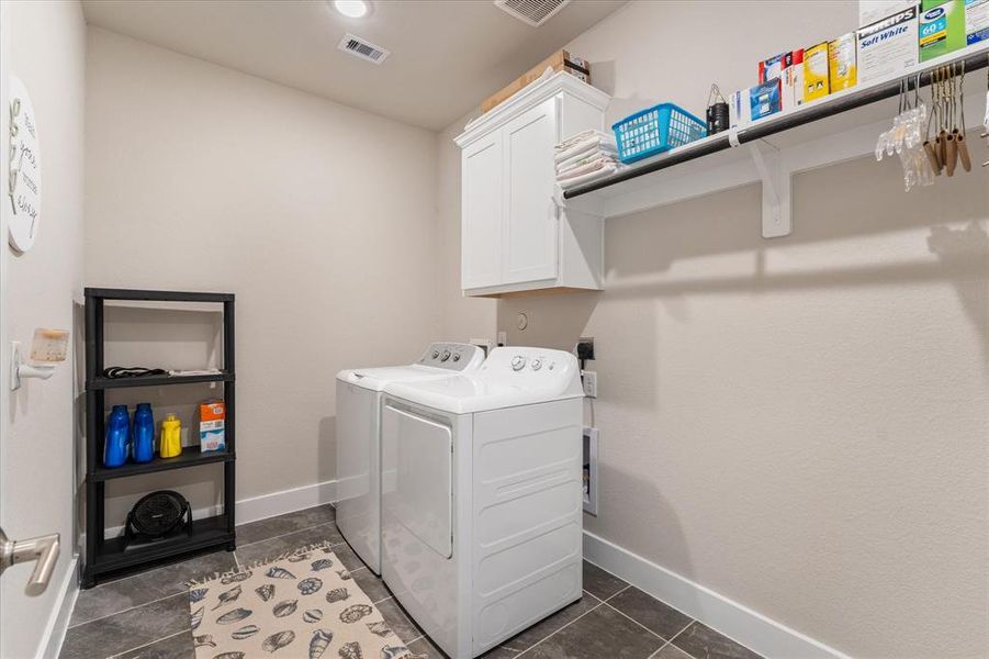 Large laundry room with tile flooring and dedicated hanging space