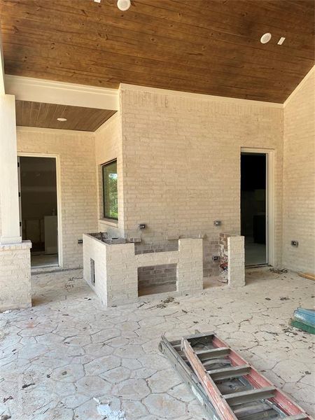 Outdoor kitchen on huge covered patio with fill bath off to left perfect for future pool