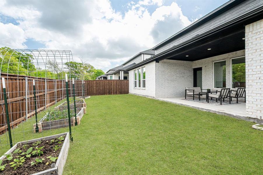 Fenced backyard featuring a garden and a patio area