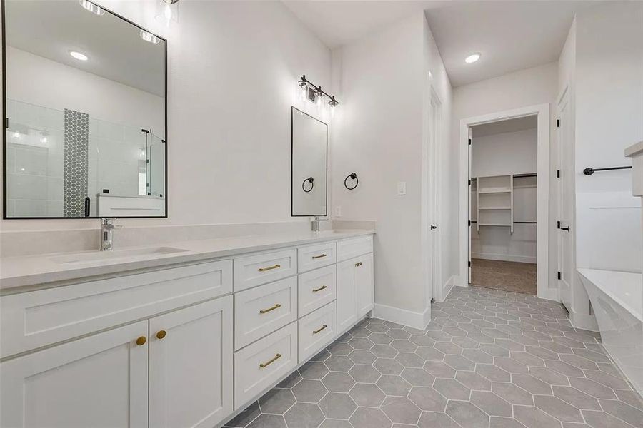 Bathroom featuring double vanity, a shower stall, a walk in closet, recessed lighting, and light tile patterned floors