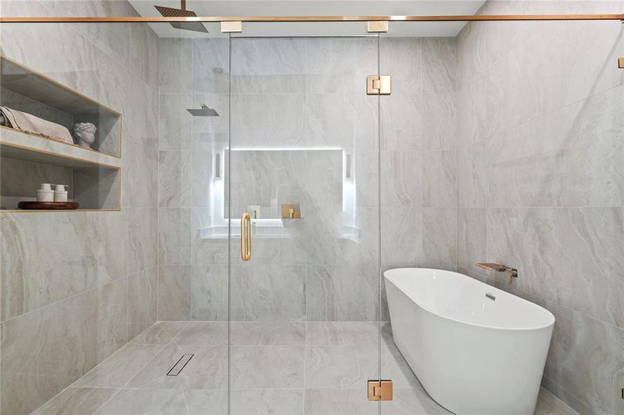 Full bathroom featuring a stall shower, a freestanding bath, and tile walls Full bathroom featuring a stall shower, a freestanding bath, and tile walls