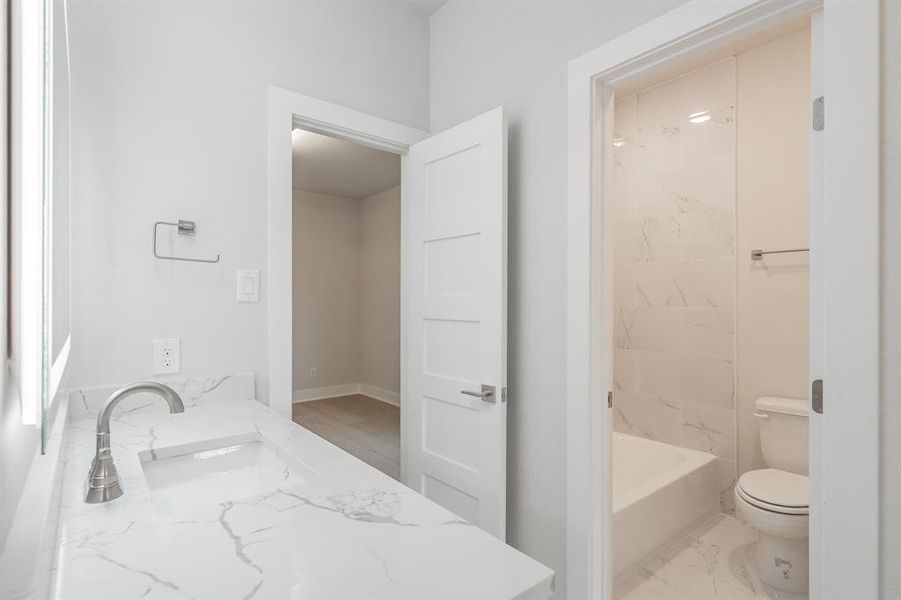 Full bath with vanity and light marble finish flooring