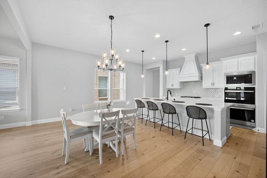 Open-concept kitchen and dining area featuring light wood-finish flooring