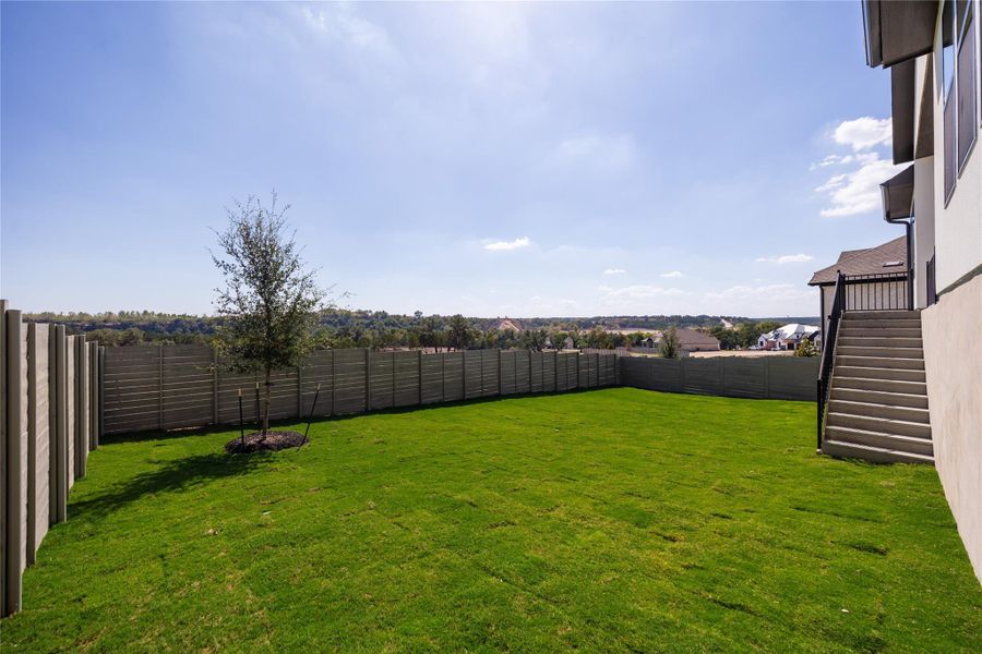 Fenced backyard featuring stairs