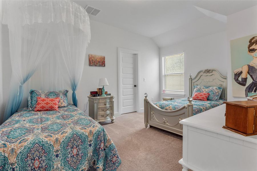 Bedroom 2 with light carpet and lofted ceiling Bedroom 2 with light carpet and lofted ceiling