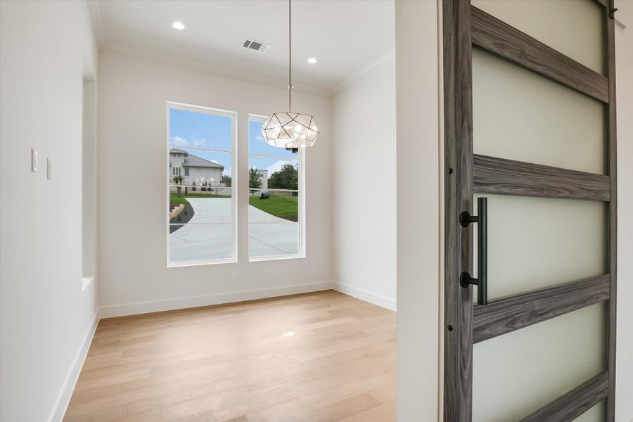 Light wood-finish flooring with crisp white baseboards and walls