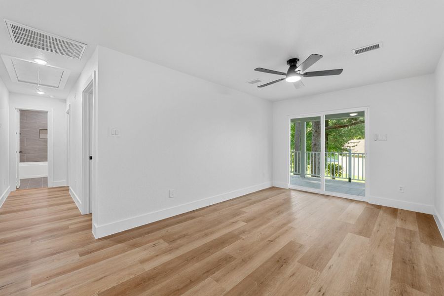 Expansive upstairs game room, perfect for entertainment and relaxation, featuring large windows and a modern ceiling fan. Expansive upstairs game room, perfect for entertainment and relaxation, featuring large windows and a modern ceiling fan.