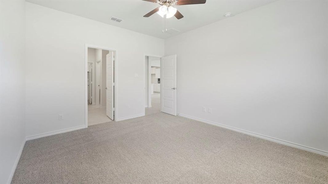 Unfurnished bedroom featuring carpet flooring, a ceiling fan, and connected bathroom Unfurnished bedroom featuring carpet flooring, a ceiling fan, and connected bathroom