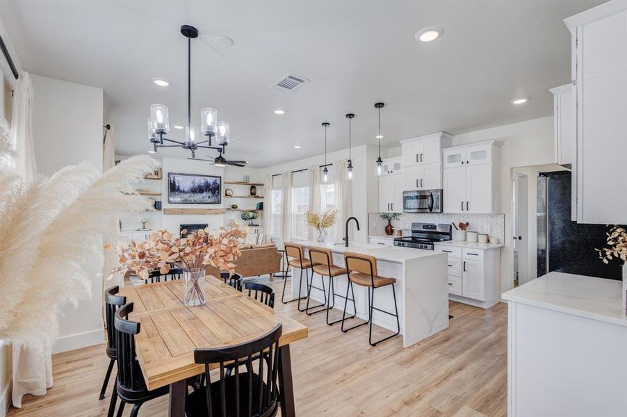 Dining space featuring ceiling fan, sink, and light wood-type flooring Dining space featuring ceiling fan, sink, and light wood-type flooring