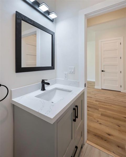 Powder Bathroom with hardwood / wood-style flooring and vanity