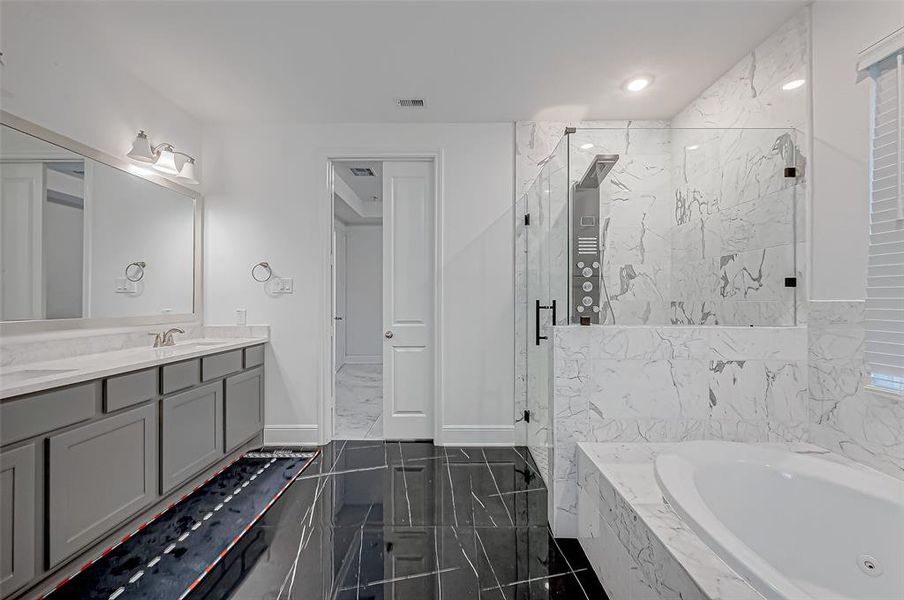 Full primary ensuite with shower featuring a rainfall system, Jacuzzi tub, double vanities, and Walk-in closet.