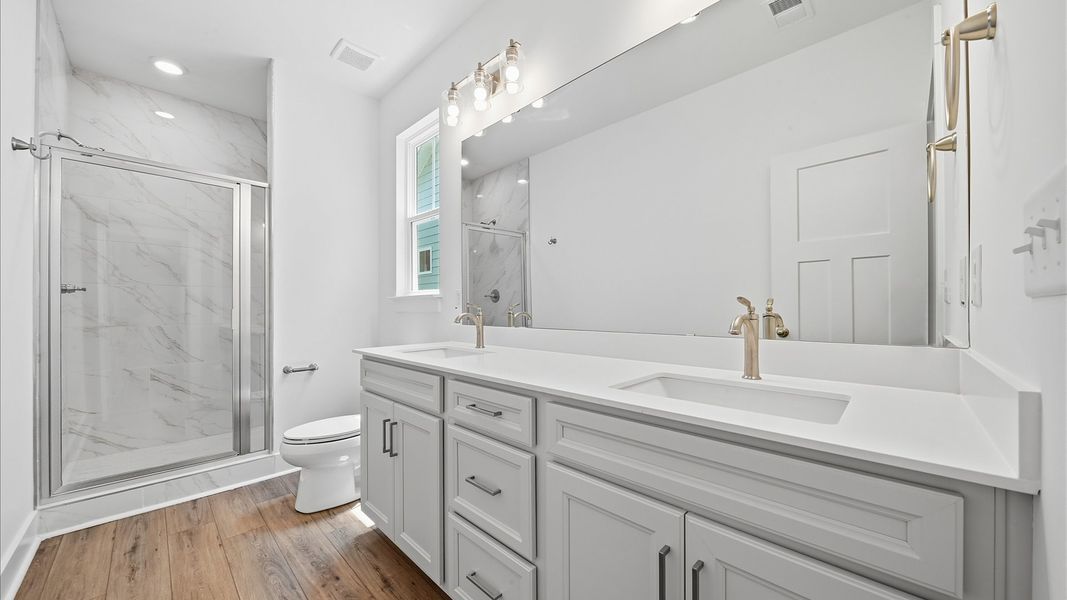 Superior en-suite primary bathroom with stylish dual vanity and tiled walk-in shower—crafted with high standards in mind Superior en-suite primary bathroom with stylish dual vanity and tiled walk-in shower—crafted with high standards in mind