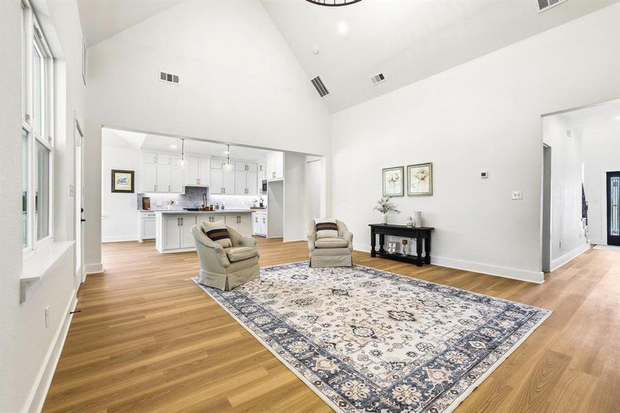Vaulted ceilings define this open-concept living space, featuring wood-finish flooring and white walls Vaulted ceilings define this open-concept living space, featuring wood-finish flooring and white walls