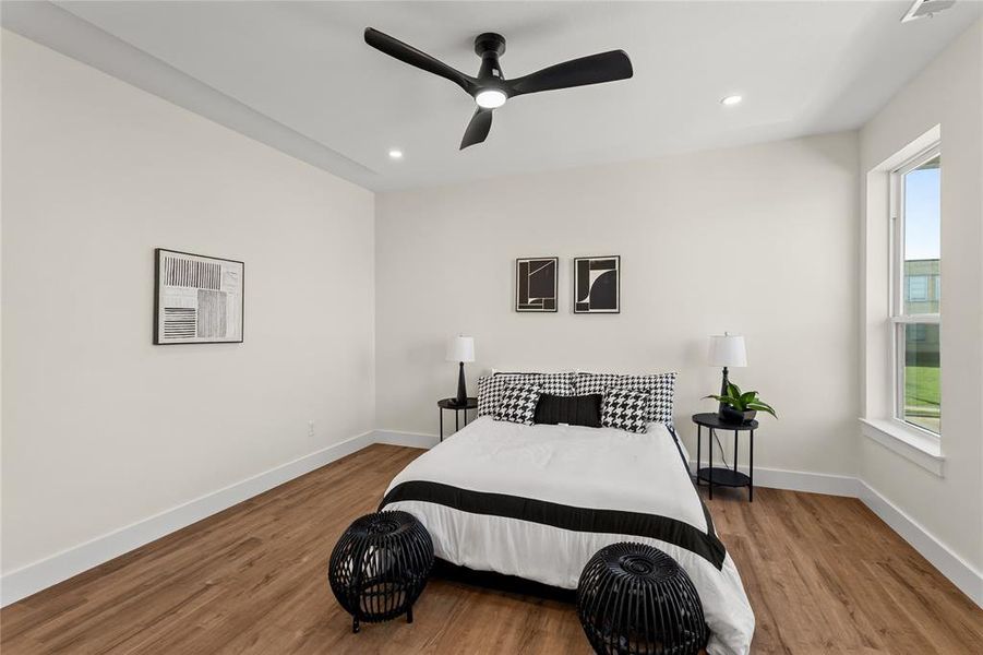 Bedroom with wood finished floors, recessed lighting, and a ceiling fan