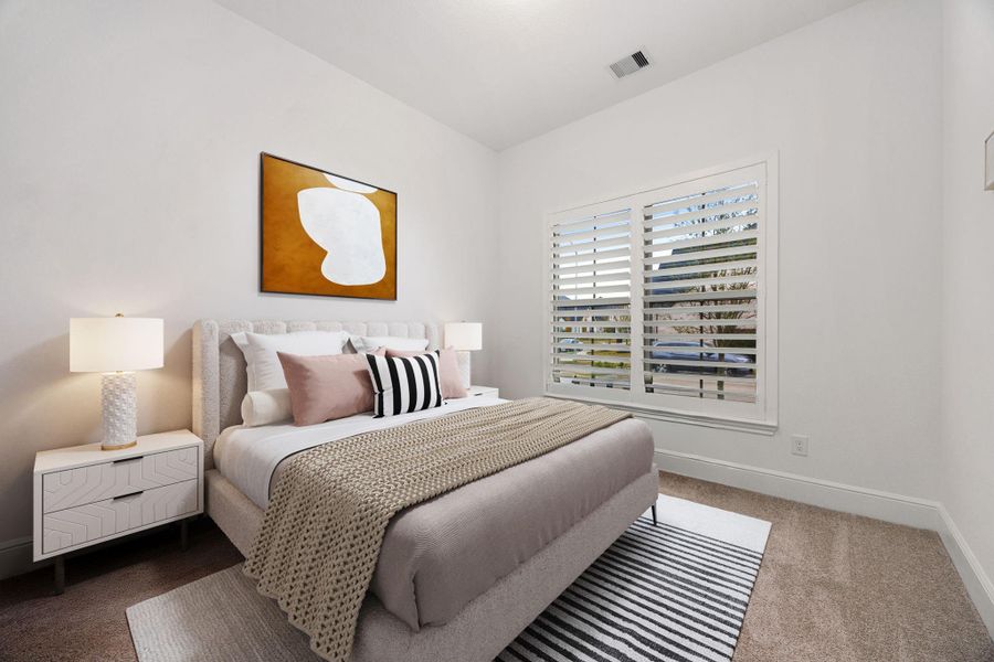 The secondary bedroom located downstairs provides a comfortable space with an open layout and plenty of natural light.