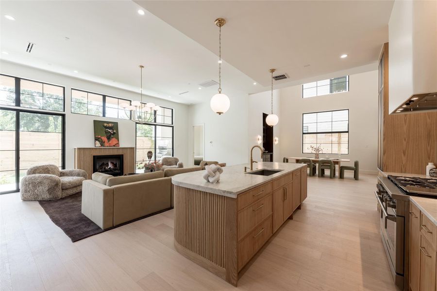 The great room balances dramatic scale with warmth, pairing 12 foot ceilings and a fluted fireplace with walls of grid windows that bring natural light deep into the space. The great room balances dramatic scale with warmth, pairing 12 foot ceilings and a fluted fireplace with walls of grid windows that bring natural light deep into the space.