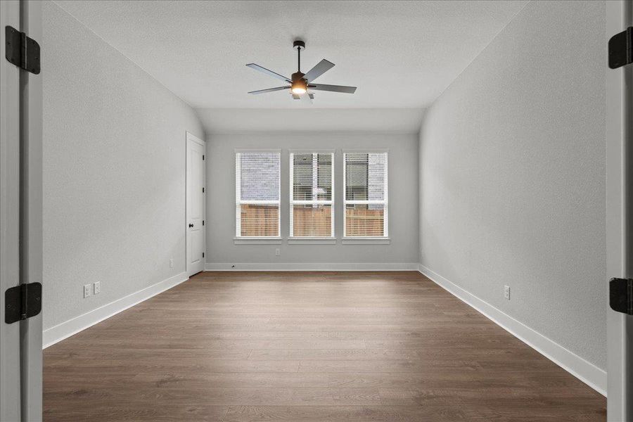 Empty room with ceiling fan, dark wood finished floors, and baseboards Empty room with ceiling fan, dark wood finished floors, and baseboards
