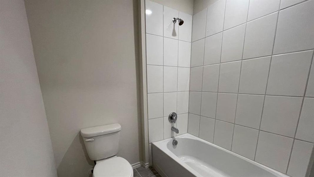 White subway tile tub surround with a chrome showerhead and faucet White subway tile tub surround with a chrome showerhead and faucet