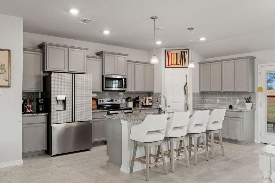 Kitchen with gray cabinets, a kitchen bar, stainless steel appliances, tasteful backsplash, and recessed lighting