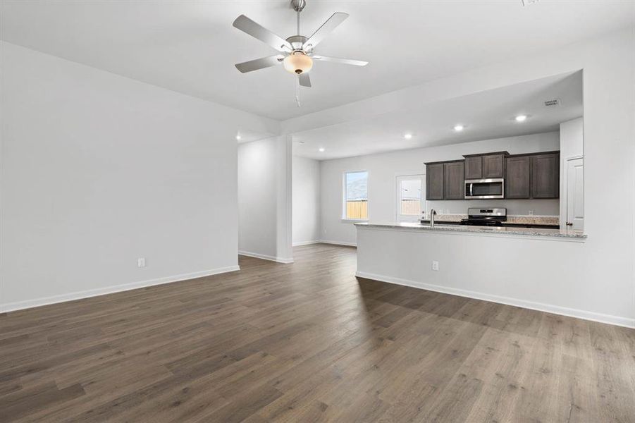 Unfurnished living room featuring recessed lighting, dark wood-style flooring, and a ceiling fan Unfurnished living room featuring recessed lighting, dark wood-style flooring, and a ceiling fan