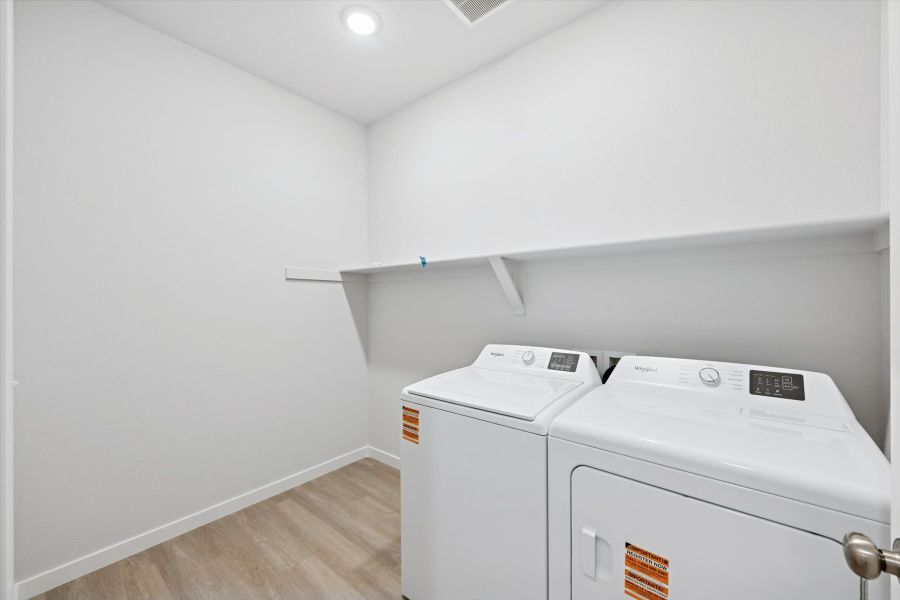 A room with a washing machine and a white wall. A room with a washing machine and a white wall.