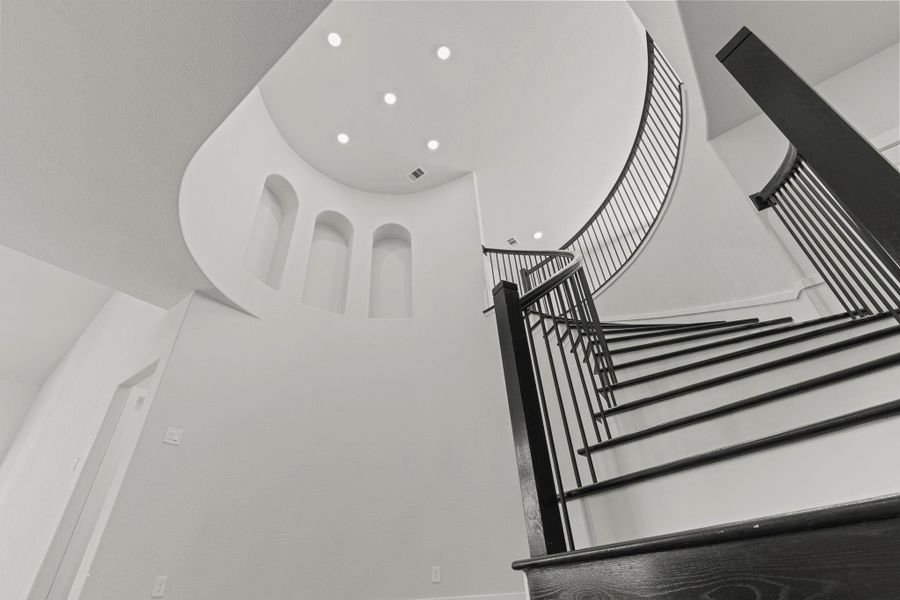 A breathtaking upward view of the staircase showcases its intricate craftsmanship and sculptural beauty — a true design statement that perfectly blends sophistication with CastleRock’s attention to architectural detail.