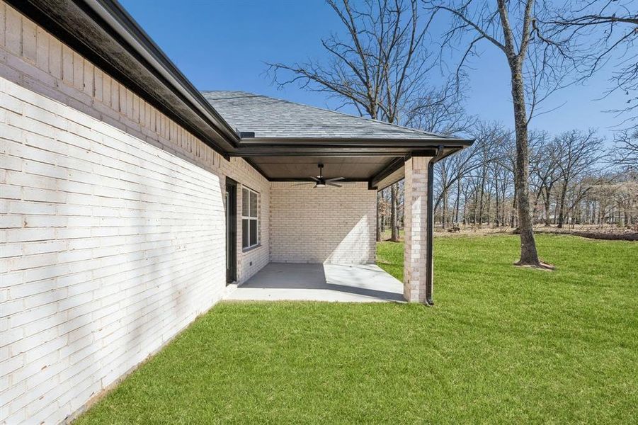 The covered back patio is a great size for enjoying the beautiful yard.