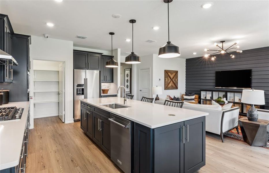 Large island overlooking gathering room and dining areas *Model Representation*