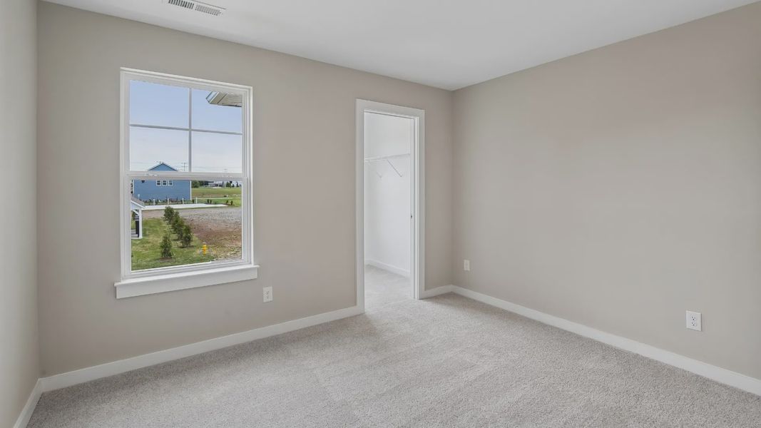 Bedroom with walk-in closet and window Bedroom with walk-in closet and window