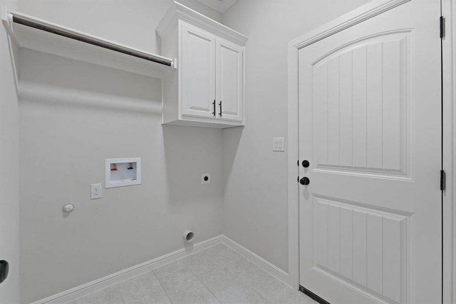 Laundry area featuring hookup for a washing machine, hookup for an electric dryer, cabinet space, gas dryer hookup, and light tile patterned floors