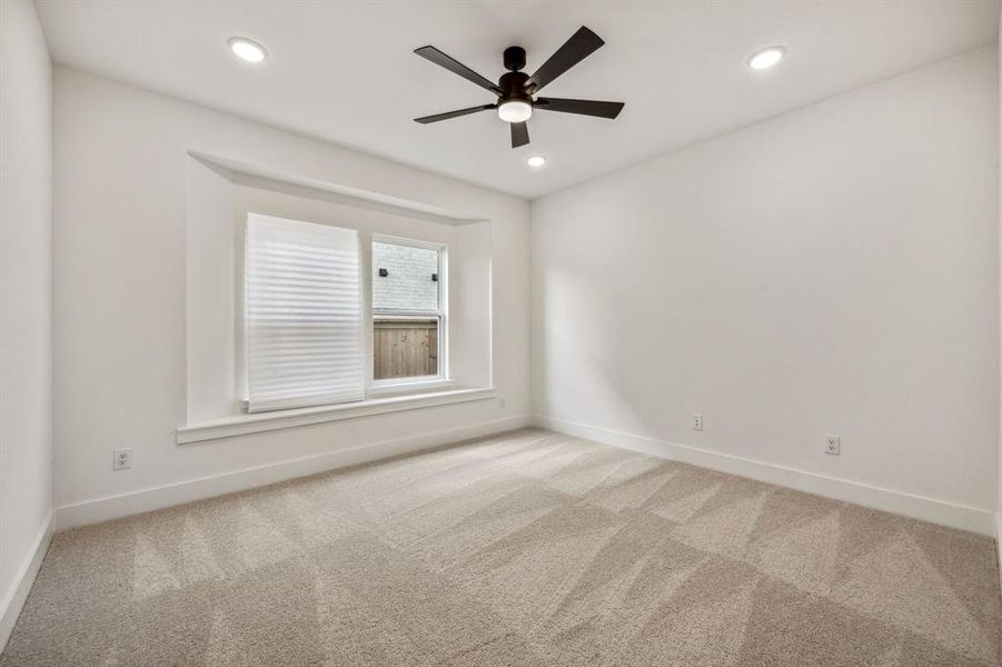 Unfurnished room featuring light colored carpet and ceiling fan