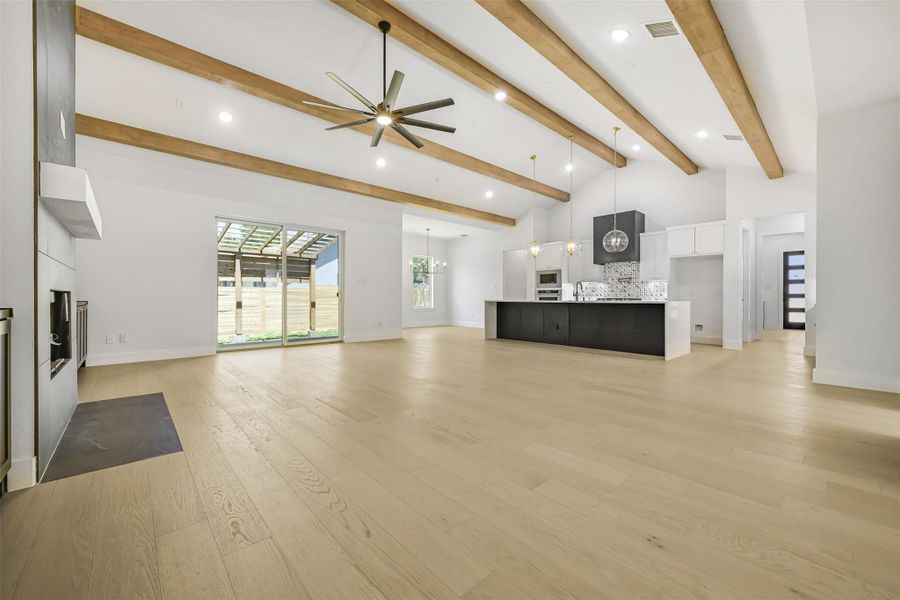 Unfurnished living room featuring ceiling fan, light wood finished floors, beam ceiling, recessed lighting, and high vaulted ceiling