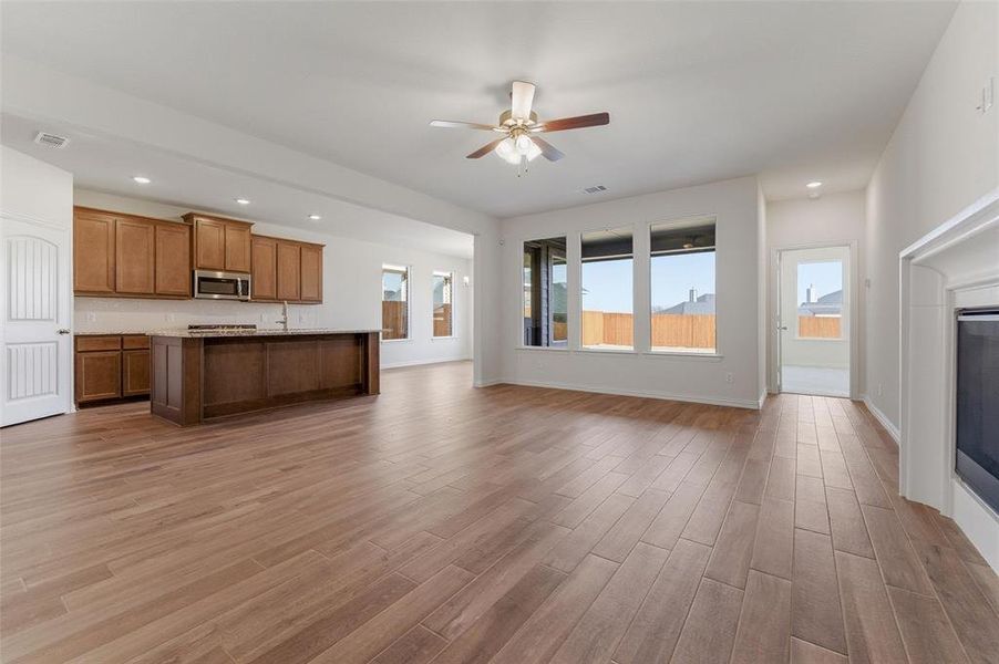 Unfurnished living room with recessed lighting, a ceiling fan, dark wood-type flooring, and a glass covered fireplace