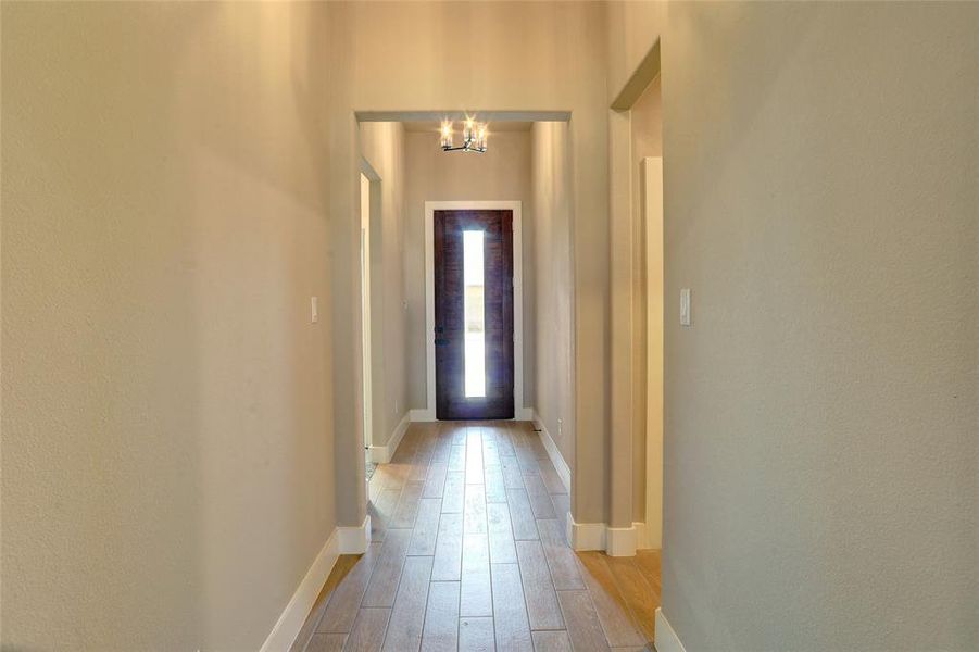 Foyer featuring light wood-style floors and a chandelier