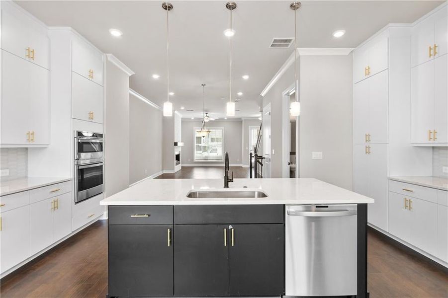 In the center of the island is the single bowl stainless sink giving you the perfect view of the main floor while dinner prepping and washing dishes. Photos are not of the exact property but are similar, the home is currently under construction.