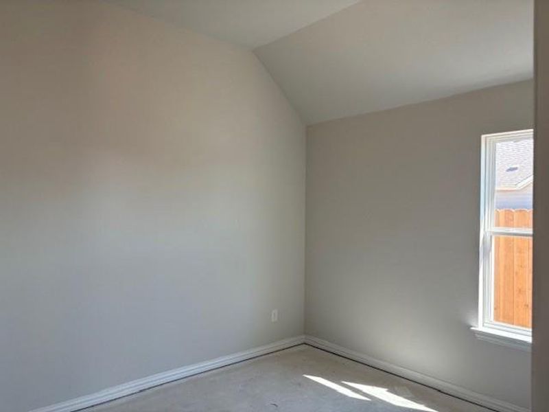 Unfurnished room featuring lofted ceiling and concrete flooring Unfurnished room featuring lofted ceiling and concrete flooring