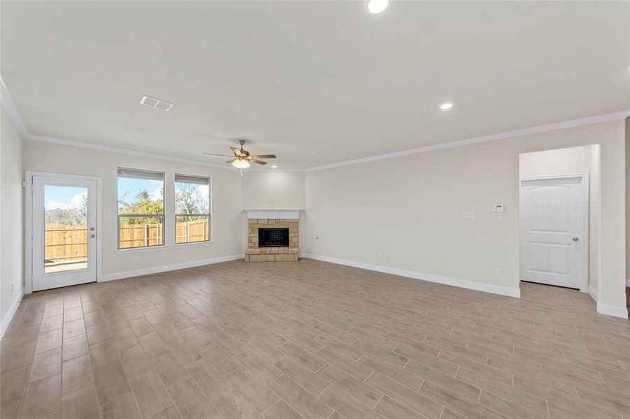 Unfurnished living room featuring ceiling fan and crown molding