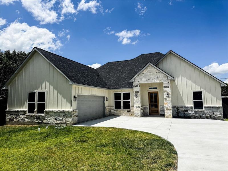 Modern inspired farmhouse with board and batten siding, an attached garage, and concrete driveway Modern inspired farmhouse with board and batten siding, an attached garage, and concrete driveway