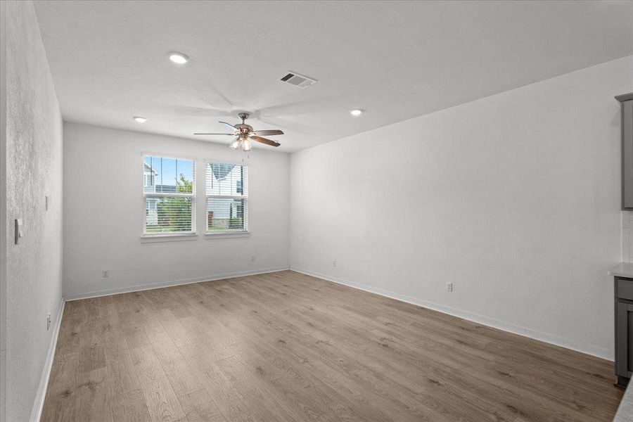 An airy room offers abundant natural light and versatile flooring, perfect for any décor.